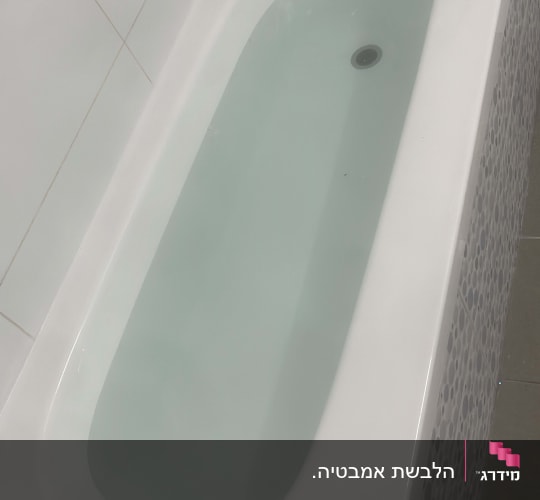 אמבטיה לבנה עם מים, אריחי קיר ורצפה